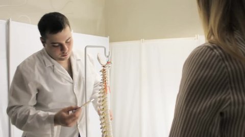 The patient listens to medical advice on topic of vertebrae in spine