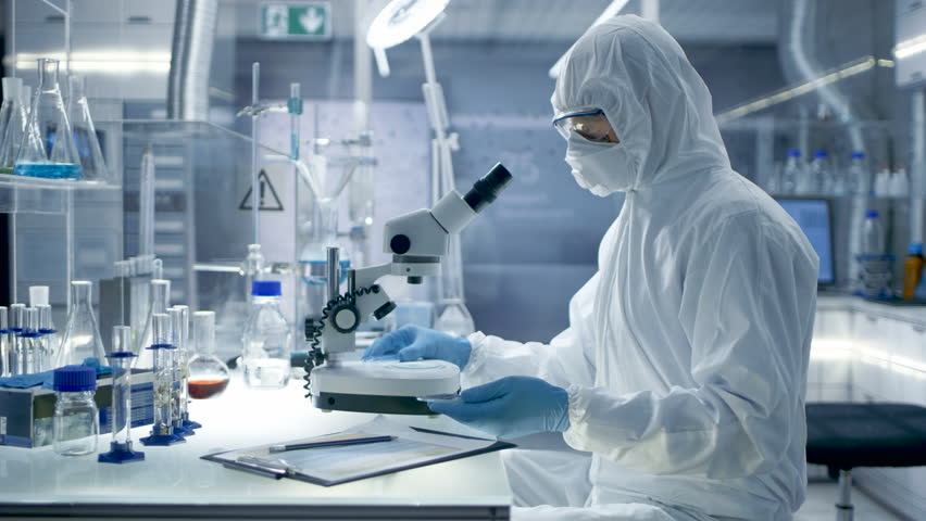 In a Secure High Level Laboratory Scientists in a Coverall Conducting a Research. Biologist Adjusts Samples in a Petri Dish with Pincers and then Examines Them Under Microscope. RED Cinema Camera. | Shutterstock HD Video #26643397