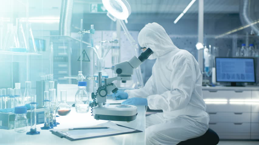 In the Secure High-Level Laboratory Scientists in a Coverall Conducting a Research. Chemist Adjusts Samples in a Petri Dish with Pincers and then Examines Them Under Microscope.RED Cinema Camera | Shutterstock HD Video #26643439