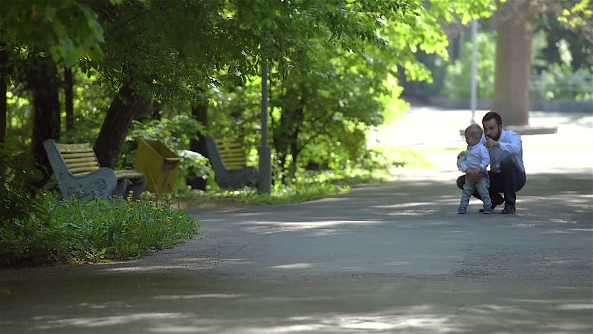 Dad and son are walking in the park. Father