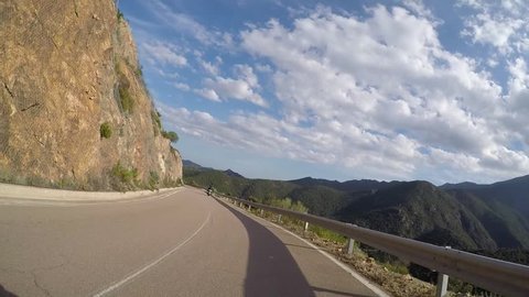 Driving curves on mountain roads with a motorcycle resp. motorbike through summer landscape with beautiful forest on Sardinia in Italy. Includes three different video sequences!