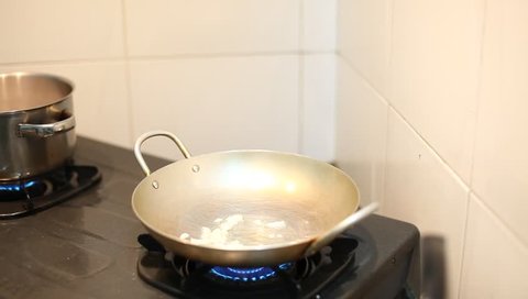 woman fry garlics in a skillet.