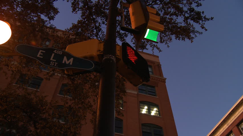 Upward rotating view of street sign and building at evening