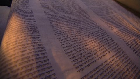 Low angled close-up of opened Torah scroll, left to right fly-over of page