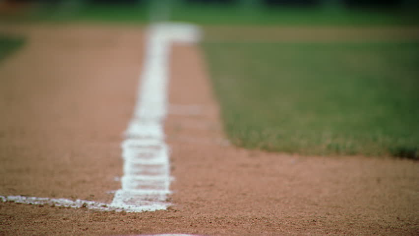 Slow-motion close-up of base runner's cleats rounding third base