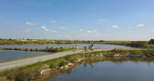 Aerial view of family riding bikes around salt marshes