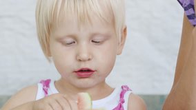 Cool blue-eyed girl for 2-3 years eats watermelon. Rural child, cute homemade video