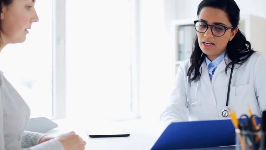Medicine, healthcare and people concept - smiling doctor with clipboard and woman patient at hospital | Shutterstock HD Video #26682733