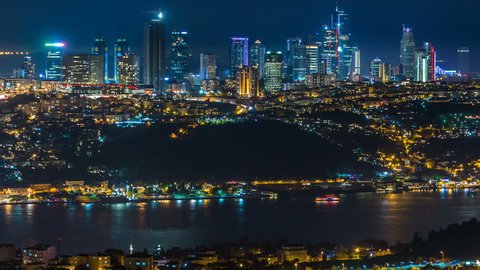 Night timelapse top view of besiktas district with some skyscrapers in istanbul taken from asian part of the city on Camlica hill. Reflection on Bosphorus water