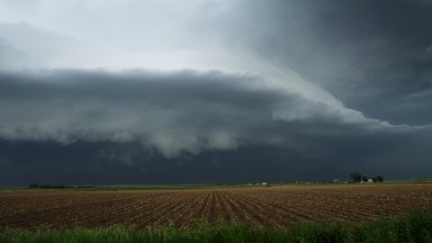 Huge shelf cloud out ahead of a cool outflow of air from a thunderstorm over farmland, time lapse