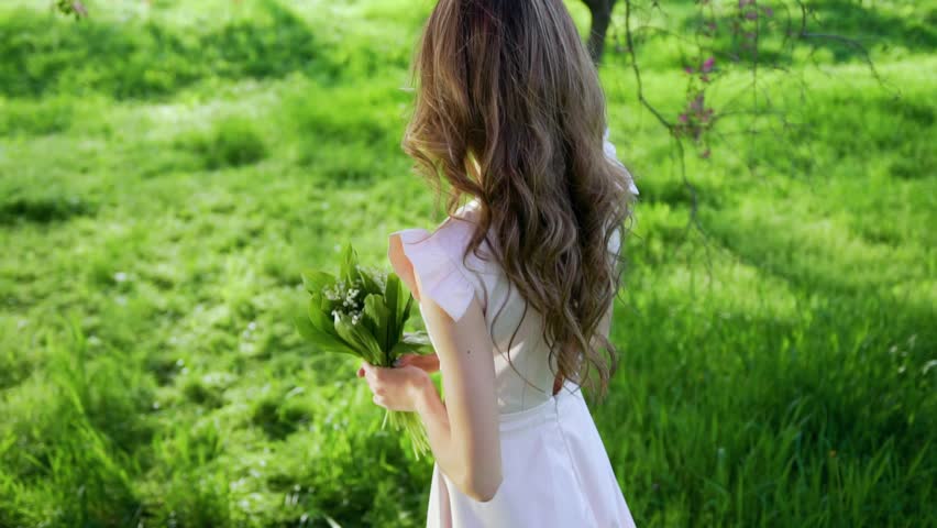 Smiling happy attractive woman goes among flowered garden and turns around Royalty-Free Stock Footage #26702275