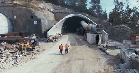 Aerial footage of a tunnel construction site with workers and equipment