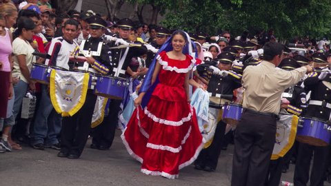 Folk dancers in flounced satin skirts performing at a parade in San Salvador