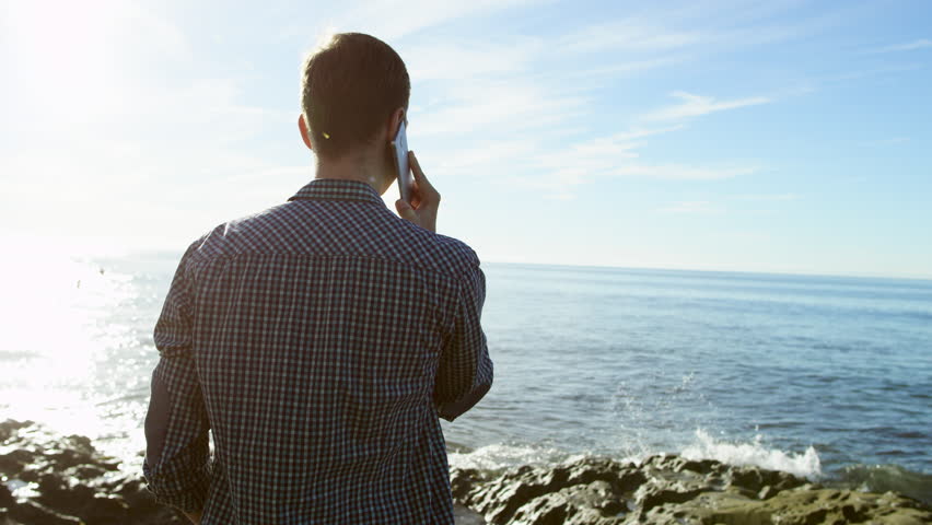 Joyful conversation over the phone on a beautiful beach