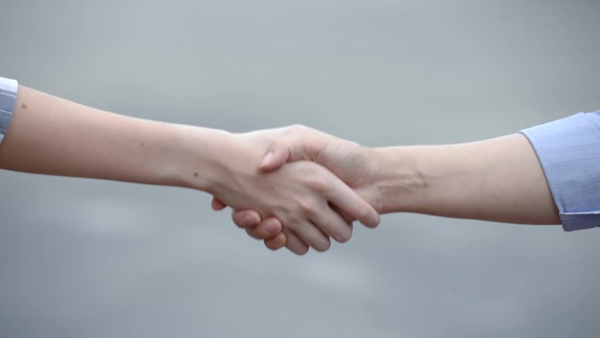 Close up view of two people shaking hands together outdoors on black background. Royalty-Free Stock Footage #26721817