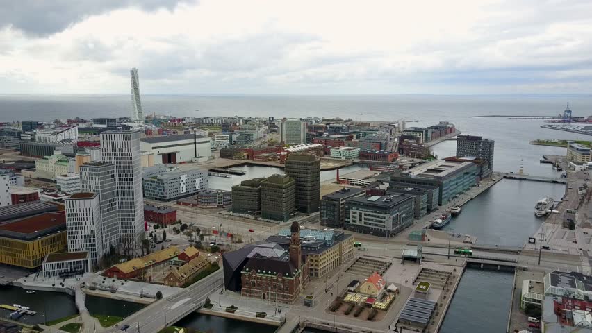 Beautiful aerial Malmo city view in Sweden with Western Harbor, Turning Torso skyscraper, city canals, and industrial buildings.