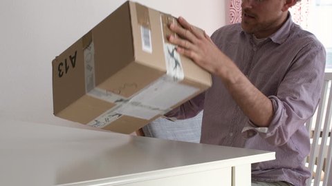 Man unboxing un packing large cardboard box - online shopping via internet