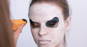Make-up artist make the girl halloween make up on white background. Halloween face art.