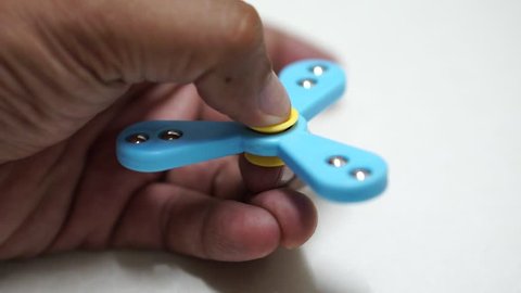 Hand spinner, or fidgeting spinner, rotating on hand