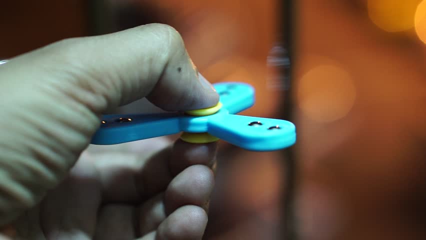 Hand spinner, or fidgeting spinner, rotating on hand