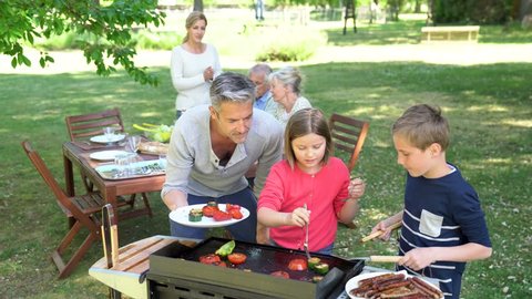 Father with kids preparing barbecue for family lunch
