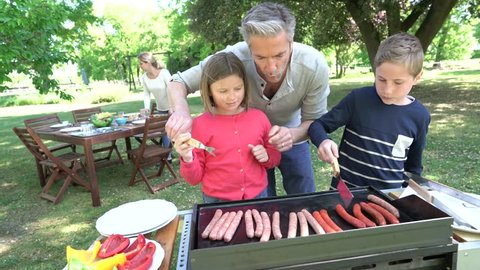 Father with kids preparing barbecue for family lunch