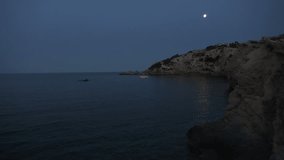 lonely boat in water with moon in night sky