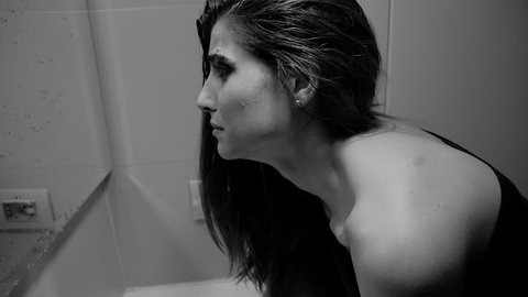 Woman with strong makeup, washing face, crying desperately. Slow motion, black and white.
