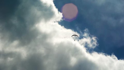 The paraglider in the sky, flies in the air streams. Freedom, when you fly like a bird, at a tremendous height. Extreme sports.