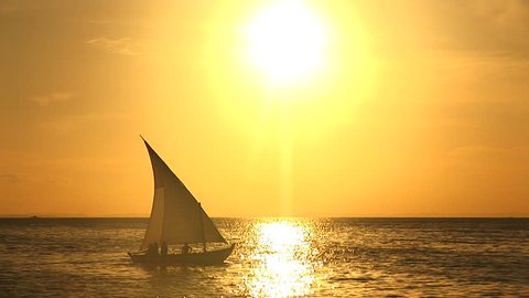 Boat in front of a big sun at Salvador, Bahia, Brazil