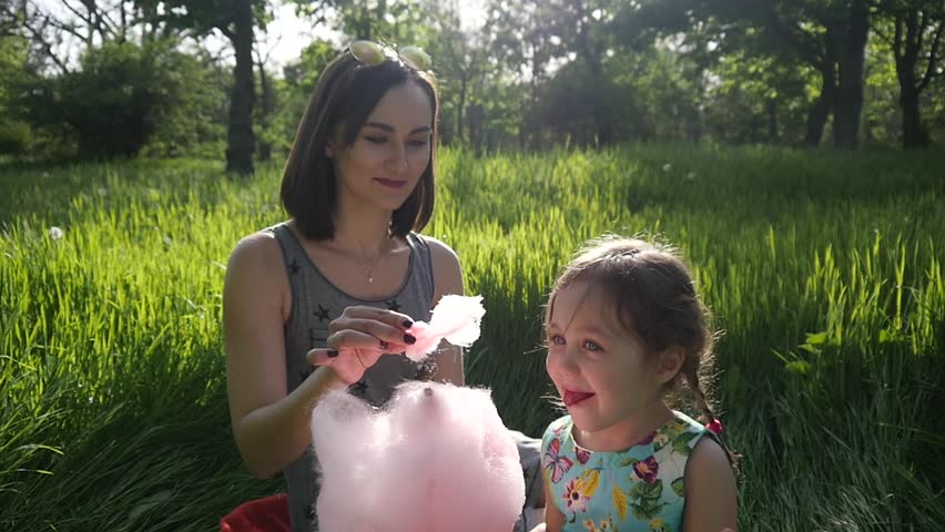 Mother Feed Her Cute Little Child Girl Eating Sweet Cotton Candy In A Green Park | Shutterstock HD Video #26783395