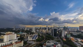 Timelapse 4K footage of a beautiful afternoon of Kuala Lumpur city view from rooftop of a building with moving vehicle and dramatic clouds. Motion Time lapse Pan Down.