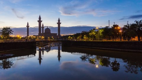 Time lapse of a mosque in Jelutong, Shah Alam, Malaysia during sunrise with reflection. 4K.