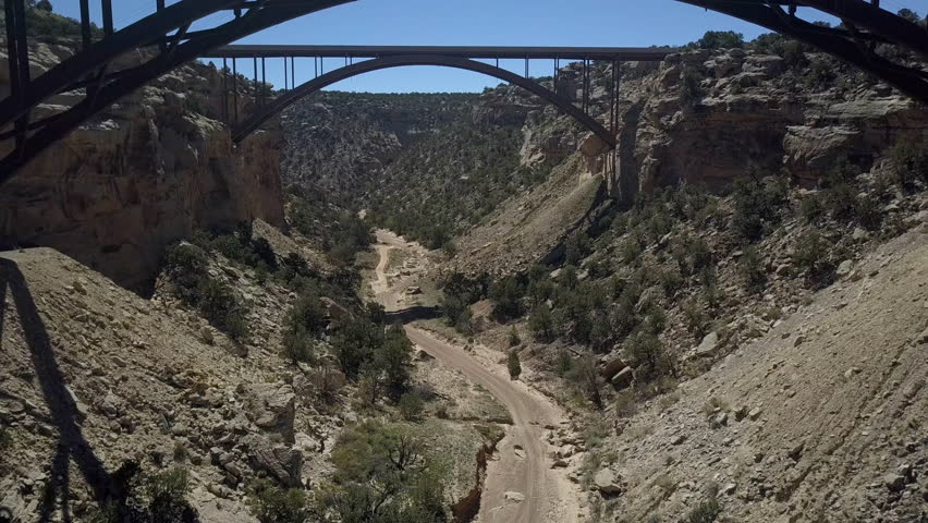 Aerial Eagle Canyon Bridge Utah climb valley to highway. Double span interstate I-70 highway crosses deep gorge. Travel traffic overhead drone view. San Rafael Reef is a geologic landscape.