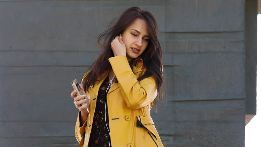 Music is always with me. Young beautiful Brunette woman listening to a song in spring park 