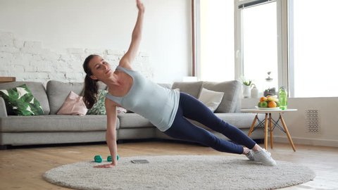 young fit and tone up woman doing fitness workout and press ups exercises for healthy lifestyle and strong hands in living room at home during sunny day