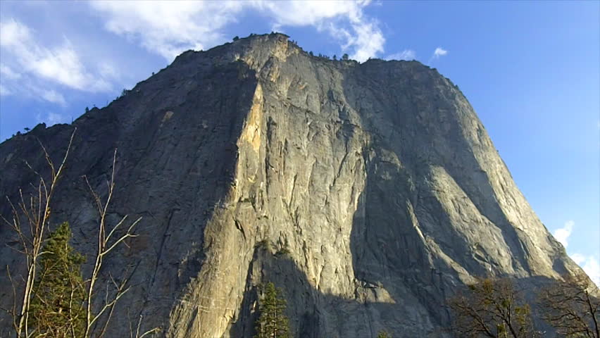 A massive granite cliff face and mountain rising high above Yosemite Valley in