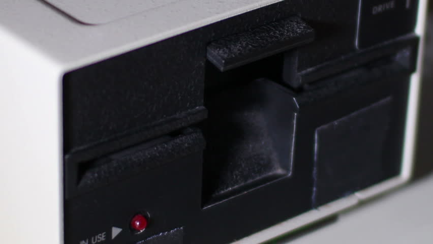 Close-up of inserting and removing an old-style 5.25" floppy disk.