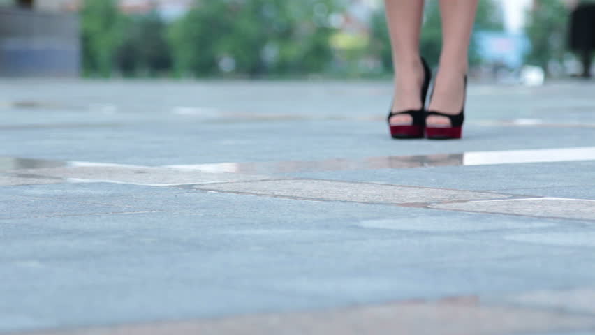 Close-up of businesswoman in modern shoes walking near the office building