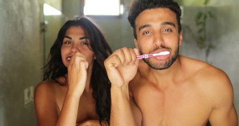 Couple Brushing Teeth In Bathroom, Cheerful Man And Woman Happy Smiling Dancing Doing Morning Hygiene Point Of View Slow Motion 60