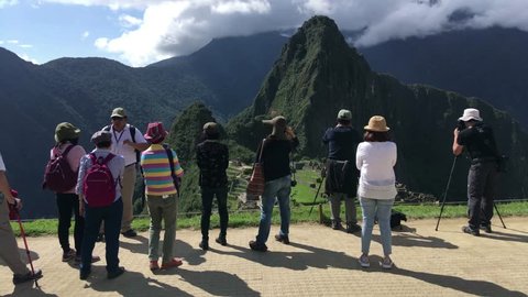MACHU PICCHU, PERU - APR 10, 2017: Tourists at Machu Picchu, the lost city of the Andes, It is located above the Sacred Valley northwest of Cuzco, Machupicchu District, Urubamba, Cusco Region, Peru.
