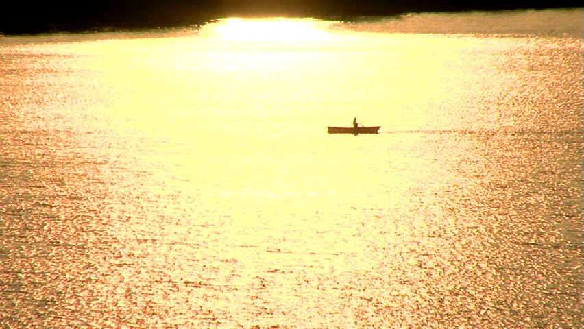 Fishermen in boat at sunset.