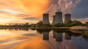Nuclear power plant by sunset in the landscape with small lake. Timelapse video.
