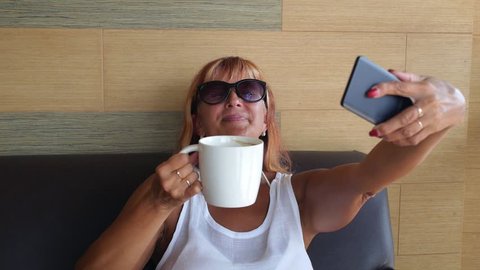 Senior Woman With Coffee Taking Selfie With Mobile Phone in Cafe. HD; 1920x1080. 