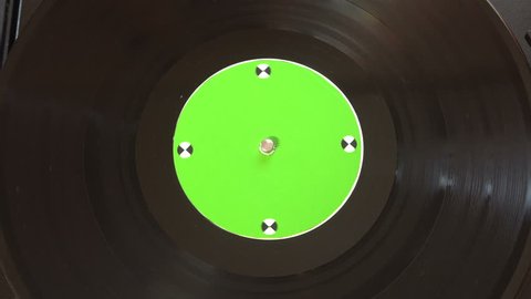 Vinyl record player. Plays song from an old turntable,4k top view. Black background. Music round plate rotate. Music disc turn. Tracking shot rotating disk with chroma-key green screen. Tracking point.