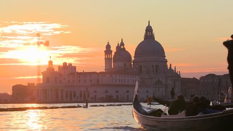 VENICE, ITALY-CIRCA 2011-A gondola is rowed by a gondolier in front of the setting sun in romantic Venice, Italy.