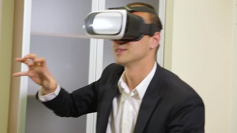 Good looking business manager relaxing at a room and using VR glasses