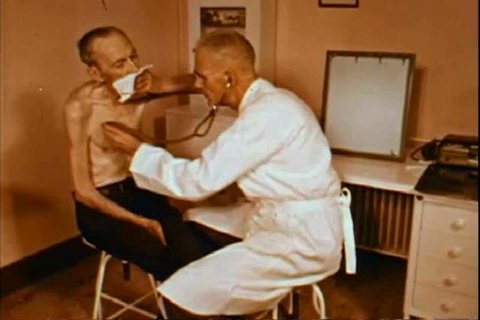 1950s: An emaciated man with emphysema is examined by a doctor in a hospital examination room in the 1950s.