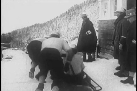 1930s: Crews race bobsleds down an ice track and crash, repeatedly, in the snow, in 1938.