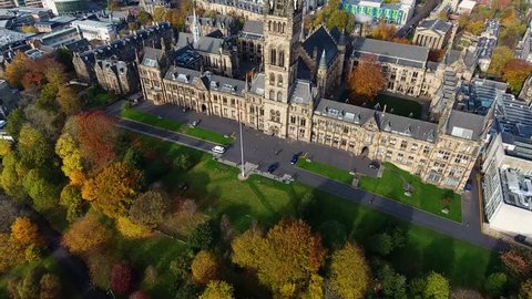 Flying in Autumn over the Kelvingrove park in Glasgow, Scotland towards the Gilbert Scott tower at Glasgow University.